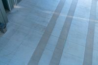 two people walking on tile that has been cleaned and polished with concrete slabs on the outside