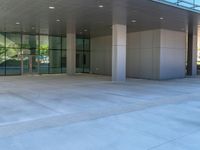 two grey blocks sitting next to a tall building on a sidewalk in front of grass