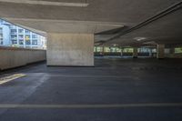 the view of an empty building from inside a parking garage area with columns and concrete walls