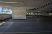 the view of an empty building from inside a parking garage area with columns and concrete walls