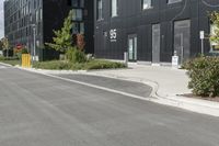 some grey buildings and black plants near the street and sky behind them with a white border