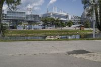 a man is standing on a street corner looking out at the water and buildings in the distance