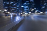 cars driving along a city street at night with lights bluring from lights shining on the pavement