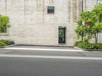 street corner in front of a brick building with no one outside it and a red stop sign