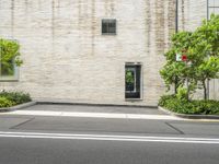 street corner in front of a brick building with no one outside it and a red stop sign