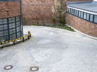 a bicycle parked in a driveway next to a building with many windows on the walls