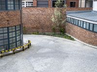 a bicycle parked in a driveway next to a building with many windows on the walls