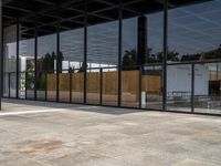 large empty patio of a large building with multiple sliding glass doors on either side and a grill area in the middle of the courtyard