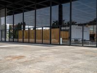 large empty patio of a large building with multiple sliding glass doors on either side and a grill area in the middle of the courtyard