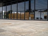 large empty patio of a large building with multiple sliding glass doors on either side and a grill area in the middle of the courtyard