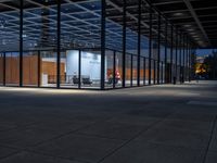 a room with a lot of glass walls and doors and people walking near by it