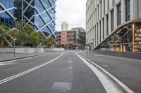 the empty road is lined with buildings along side it and surrounded by tall glass buildings