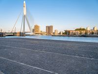 a bridge is over an empty city street with buildings in the background and the water