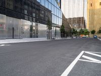 an empty road in the city near tall buildings with windows and traffic signs on it