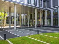 a building is shown with large columns and many bicycles parked outside the front door area