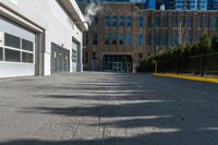 the sidewalk in front of the large buildings has yellow border on it to a black fence