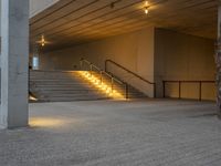 a stairway leading up to the top of a concrete building with stairs and a lit area for the light to enter