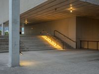 a stairway leading up to the top of a concrete building with stairs and a lit area for the light to enter