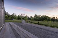 a paved pathway leading into the evening sun set and forest in background with dusk colors