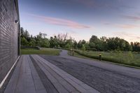 a paved pathway leading into the evening sun set and forest in background with dusk colors