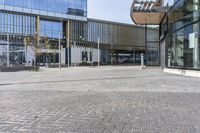 a large building that has a large glass window near it's entrance to a city