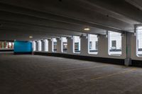 a large, empty parking garage with three windows in it and one empty, grey floor