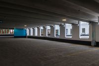 a large, empty parking garage with three windows in it and one empty, grey floor