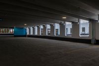 a large, empty parking garage with three windows in it and one empty, grey floor