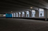 a large, empty parking garage with three windows in it and one empty, grey floor