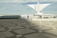 a white sculpture sitting in the middle of a tiled area under blue skies with a sky background