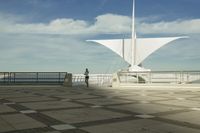 a white sculpture sitting in the middle of a tiled area under blue skies with a sky background