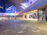 a couple of large glass buildings next to each other at night in a city area