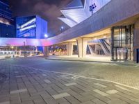 a couple of large glass buildings next to each other at night in a city area