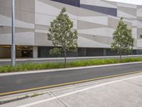 a building that is next to a road with two trees in front of it on either side of it