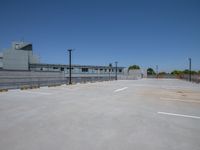 this is a concrete parking lot with a white line in it that shows an industrial building