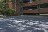 empty parking lot next to a parking garage in a building with trees growing on the side