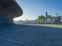 a paved road is next to a river and buildings in hong kong kong area during sunrise