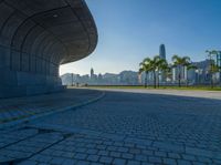 a paved road is next to a river and buildings in hong kong kong area during sunrise