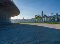 a paved road is next to a river and buildings in hong kong kong area during sunrise