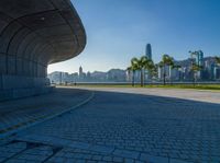 a paved road is next to a river and buildings in hong kong kong area during sunrise