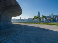 a paved road is next to a river and buildings in hong kong kong area during sunrise