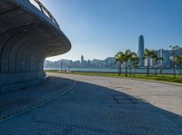 a paved road is next to a river and buildings in hong kong kong area during sunrise