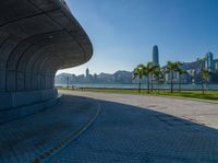 a paved road is next to a river and buildings in hong kong kong area during sunrise