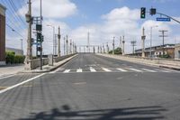 a empty street with lots of poles and overhead traffic lights on the sides of it