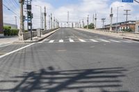 a empty street with lots of poles and overhead traffic lights on the sides of it