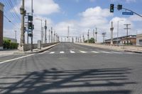 a empty street with lots of poles and overhead traffic lights on the sides of it