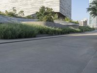 there is a woman riding a bike on the sidewalk in front of an urban building