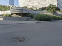 there is a woman riding a bike on the sidewalk in front of an urban building