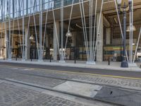 the modern building has a curved facade and steel poles with a large window on it