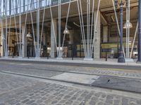 the modern building has a curved facade and steel poles with a large window on it